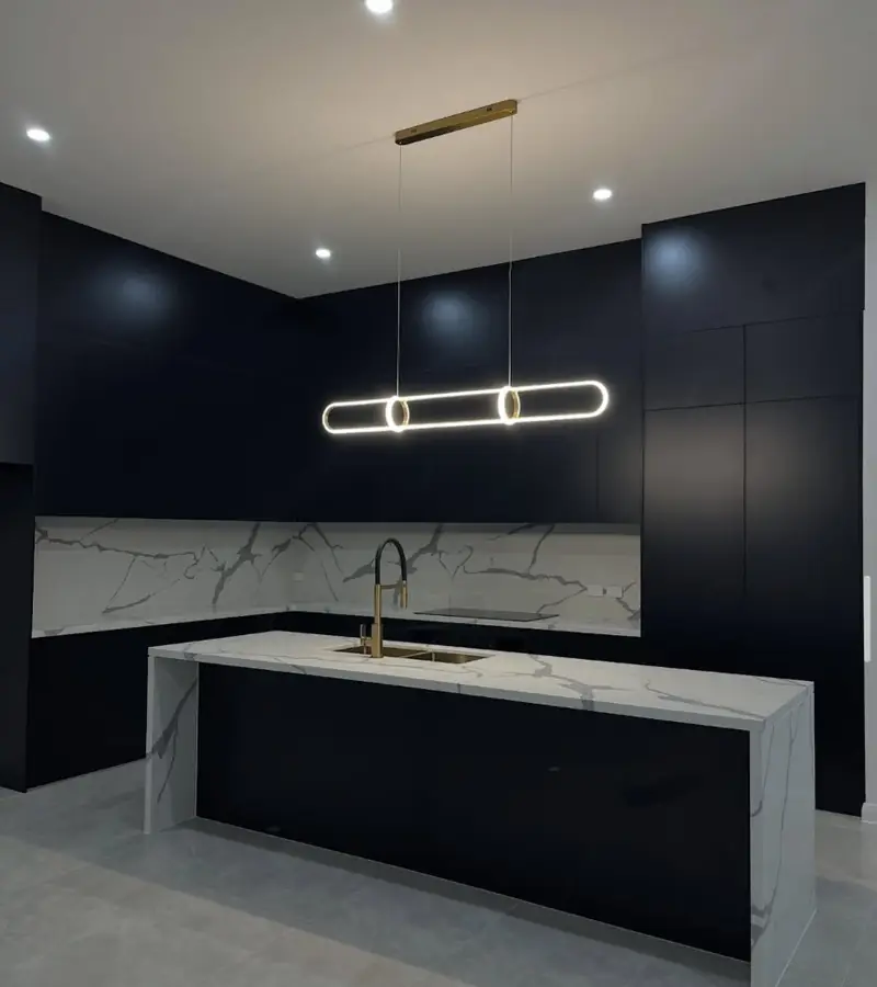 Matte black kitchen with marble island in West Pennant Hills, all joints professionally caulked
