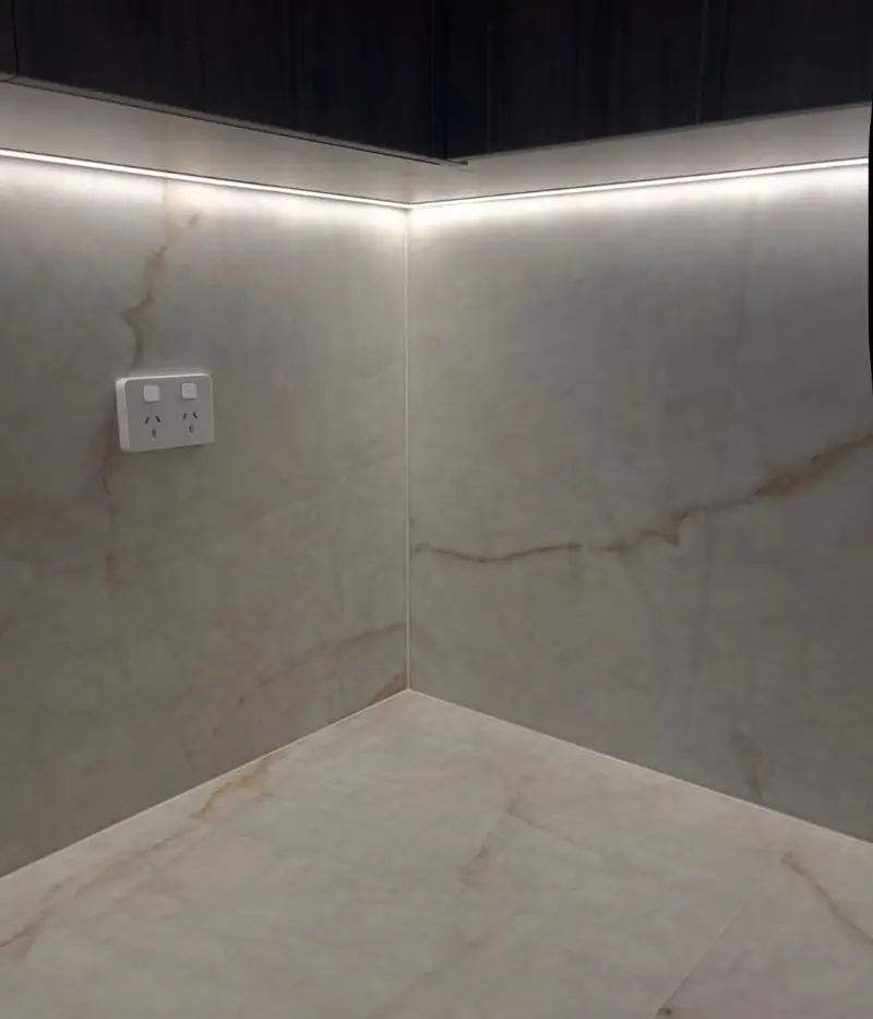 Marble tiled butler pantry corner with precise silicone seal along the wall and floor junction