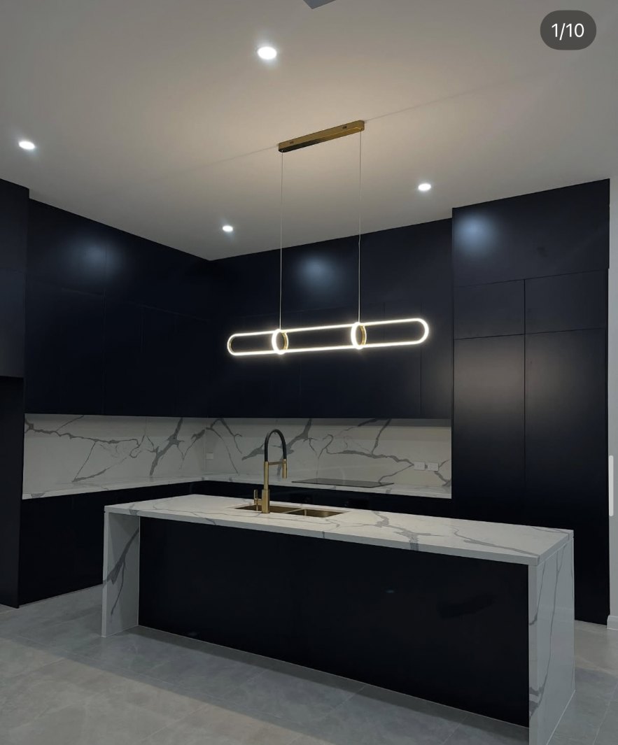 Matte black kitchen with marble island in West Pennant Hills, all joints professionally caulked